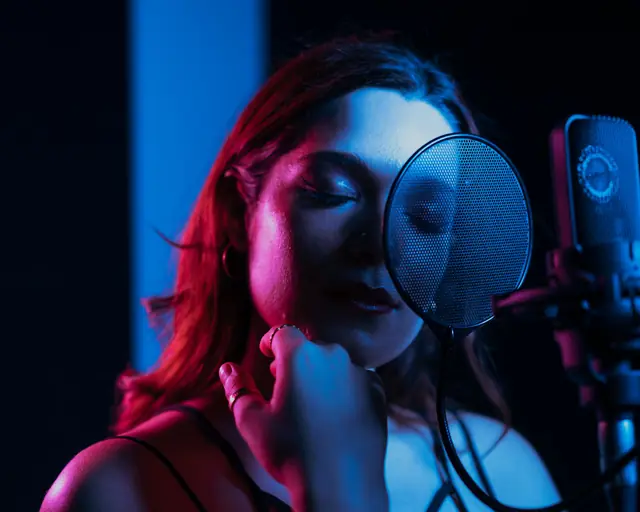 Singer recording vocals at a studio microphone