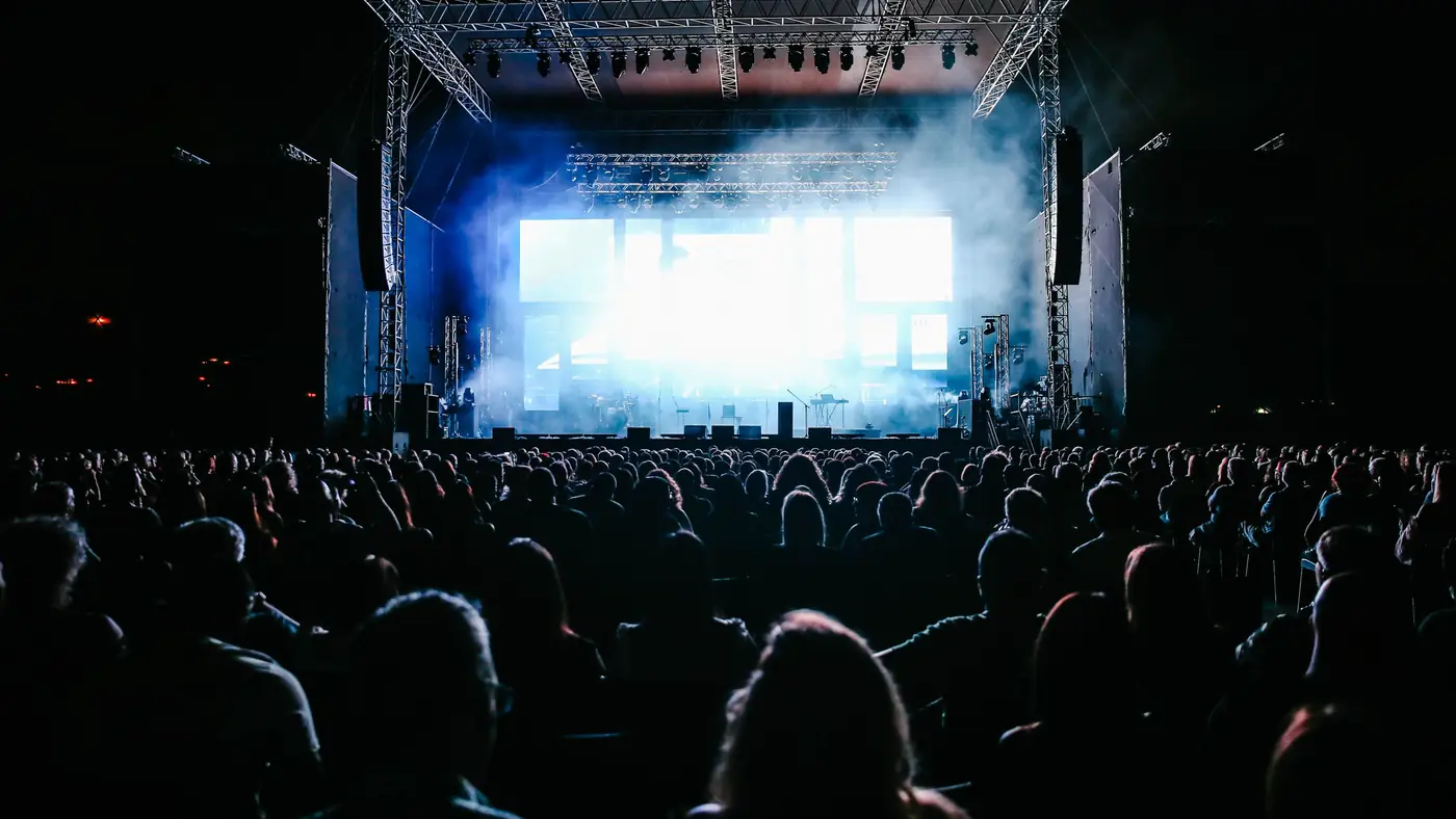 Audience facing a brightly lit concert stage