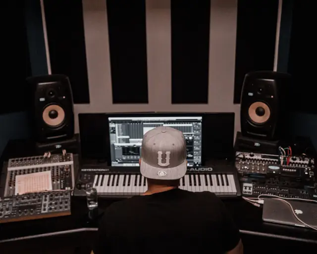 Producer working at a studio desk between two monitors